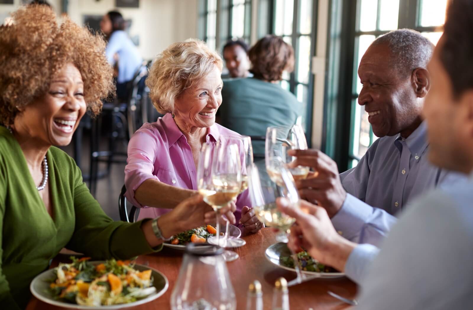 A group of seniors socialize with friends over a healthy and delcious dinner in assisted living