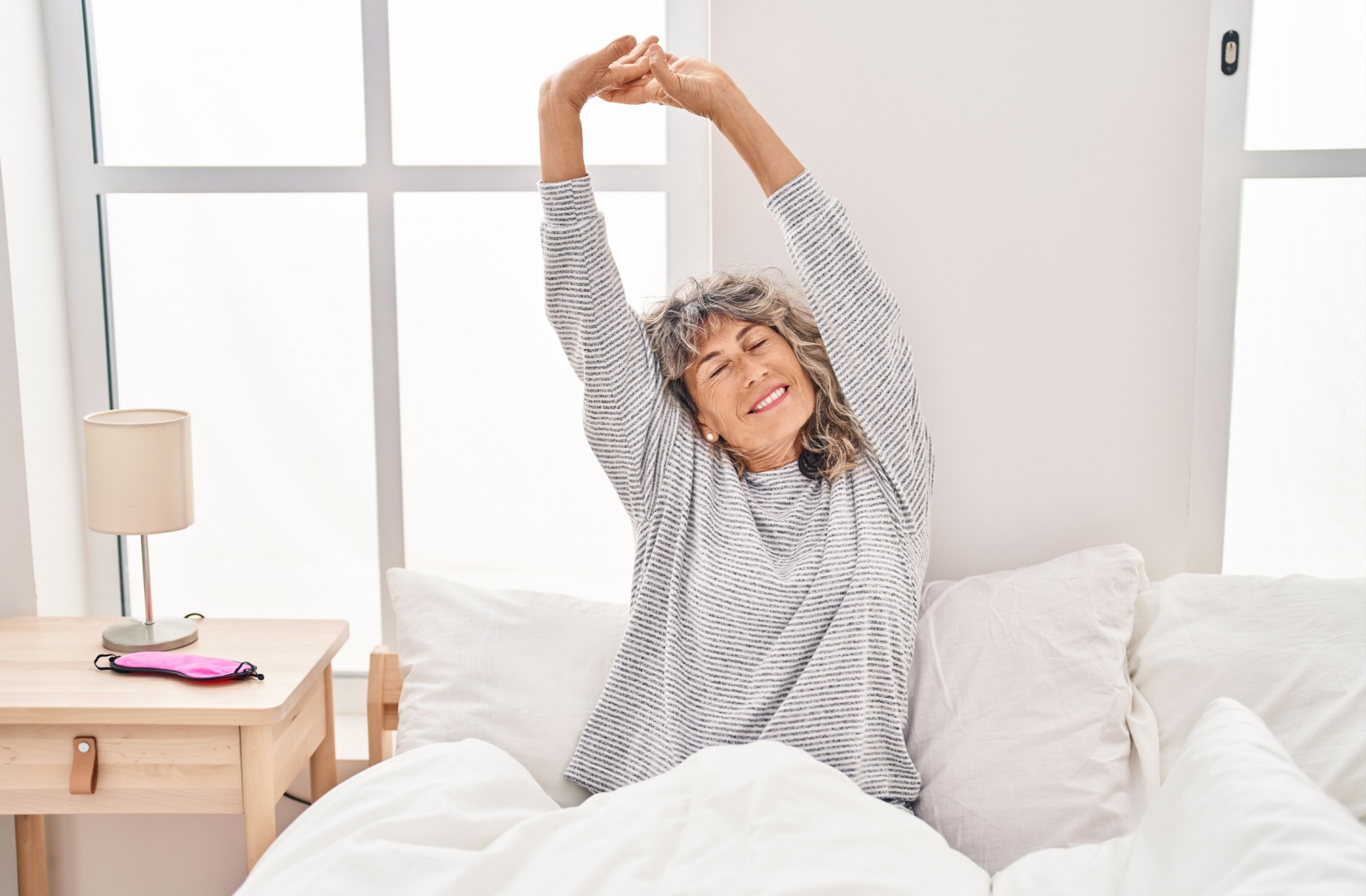 A well-rested senior stretches upon waking up, excited for a day of activities and hobbies to engage in senior living